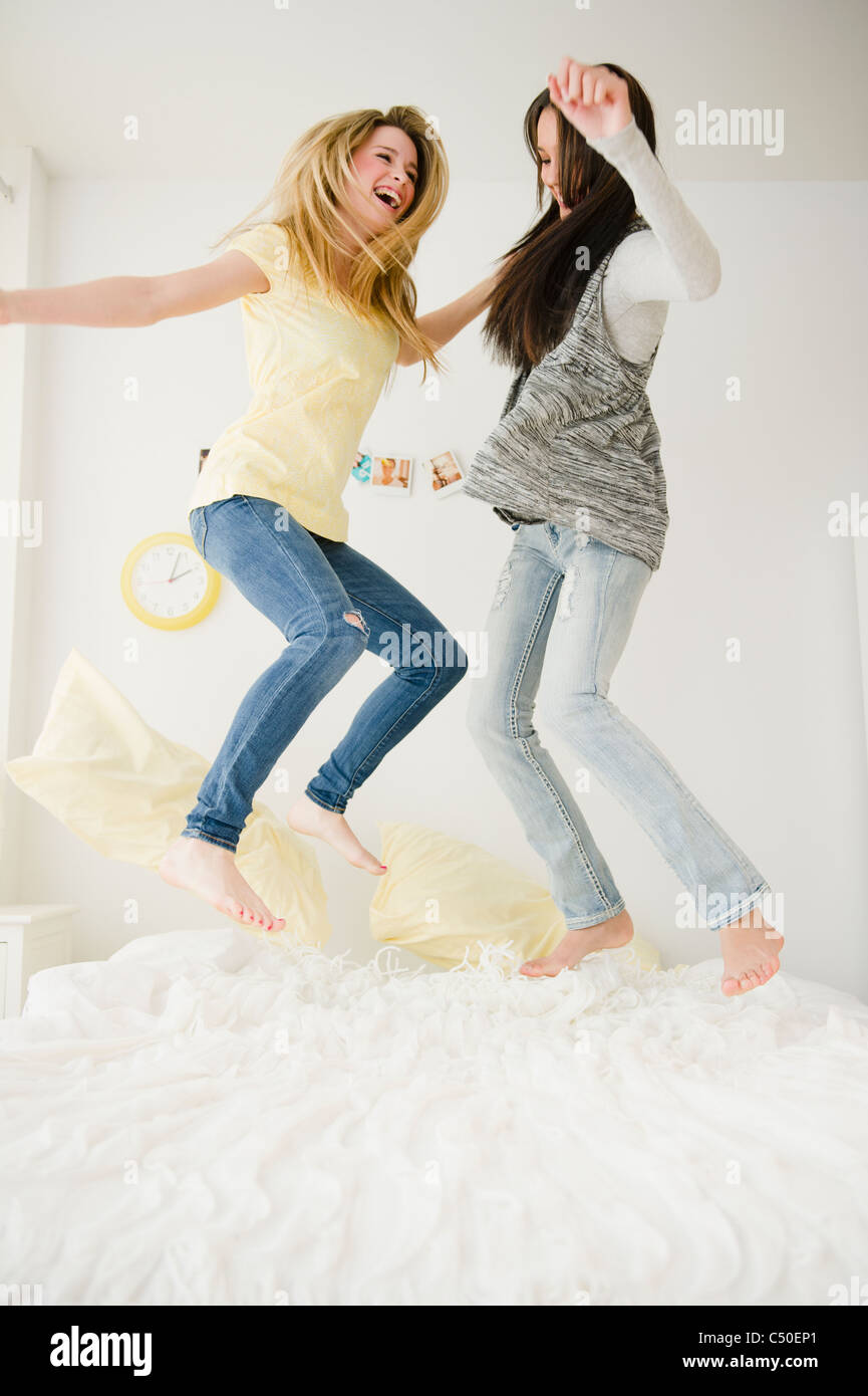 Teenage girls jumping on bed together Stock Photo Alamy