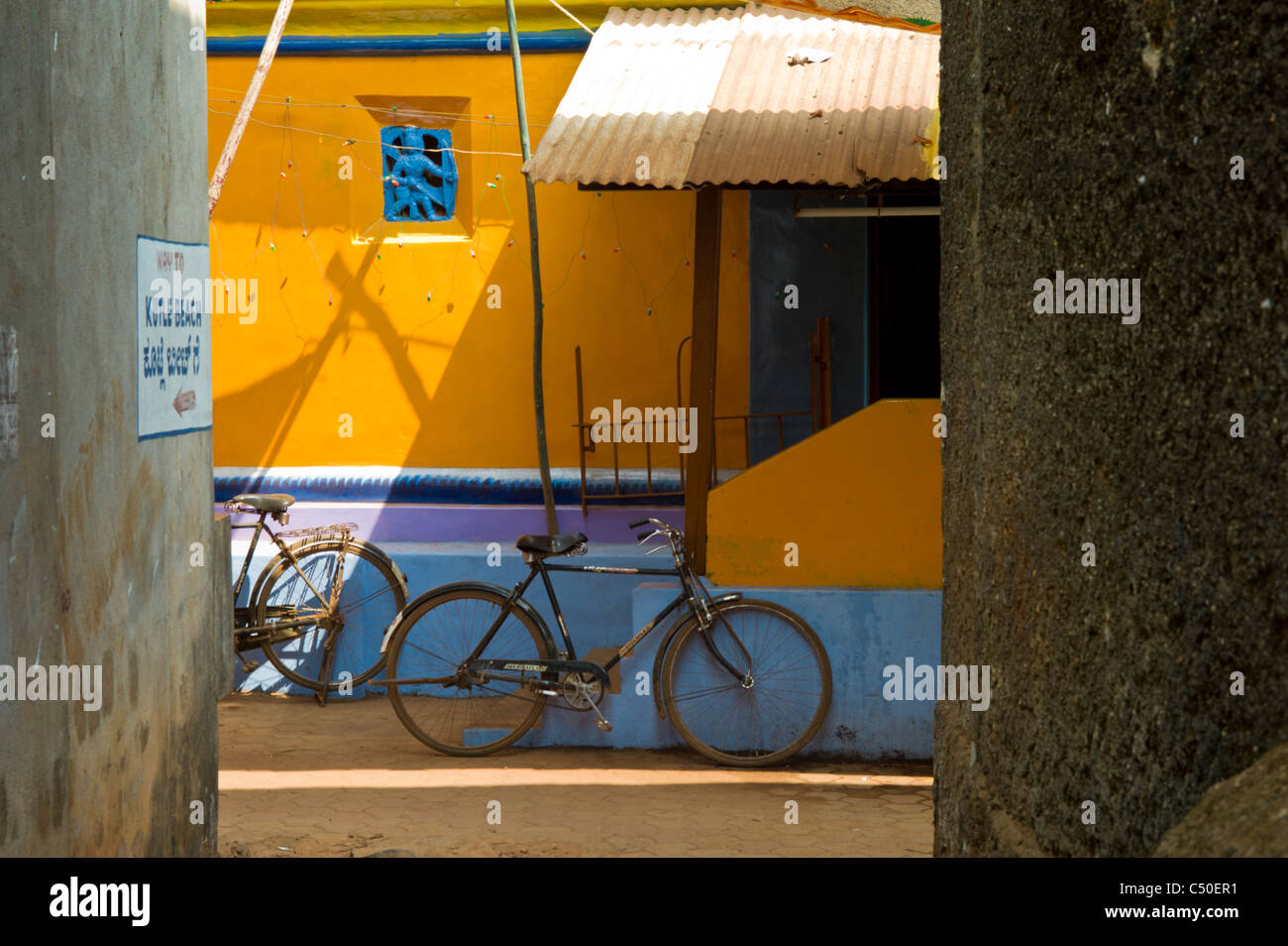 Bicycles parked in a small alley in Gokarna, India. Stock Photo