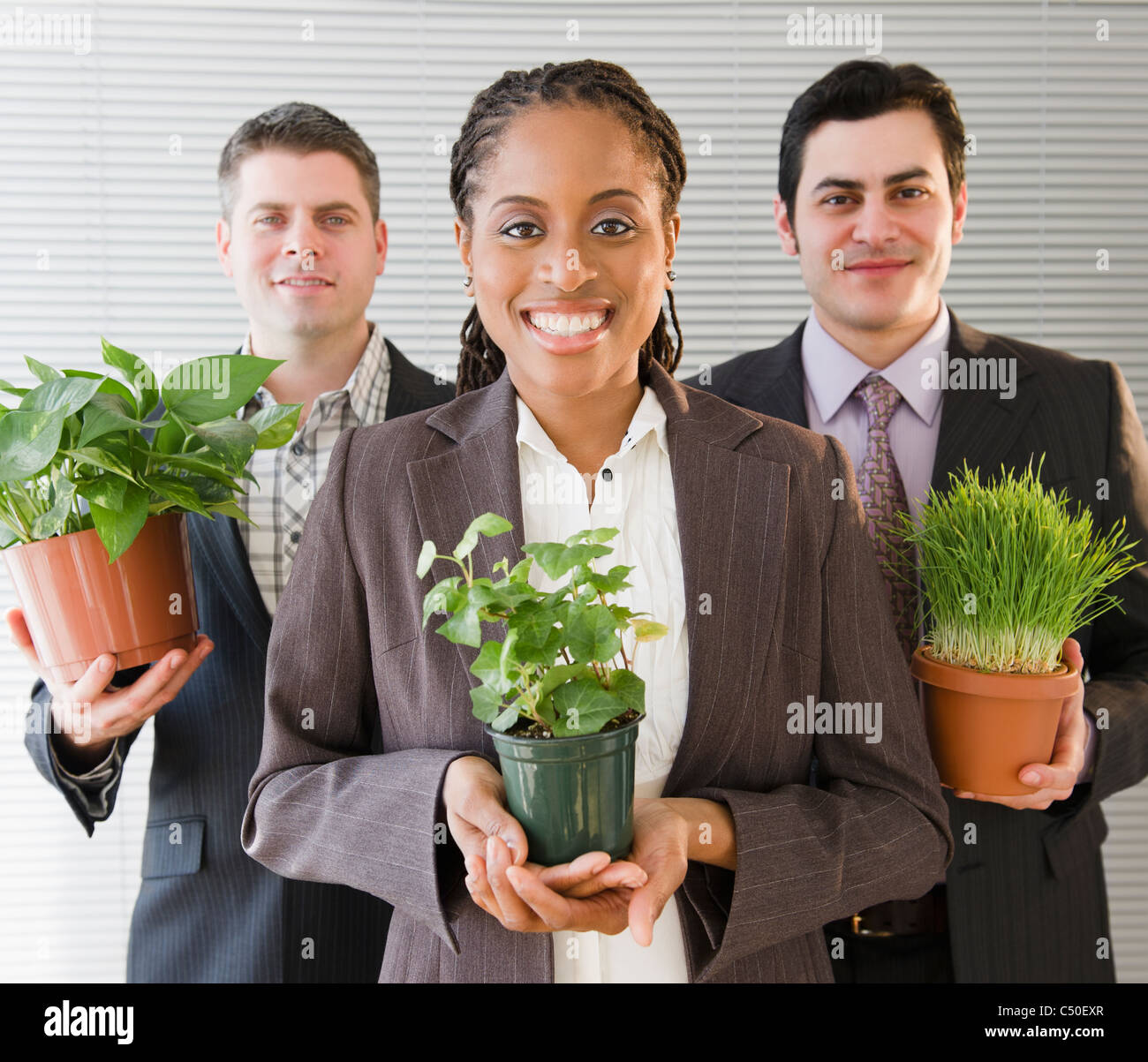 Business people holding potted plants Stock Photo