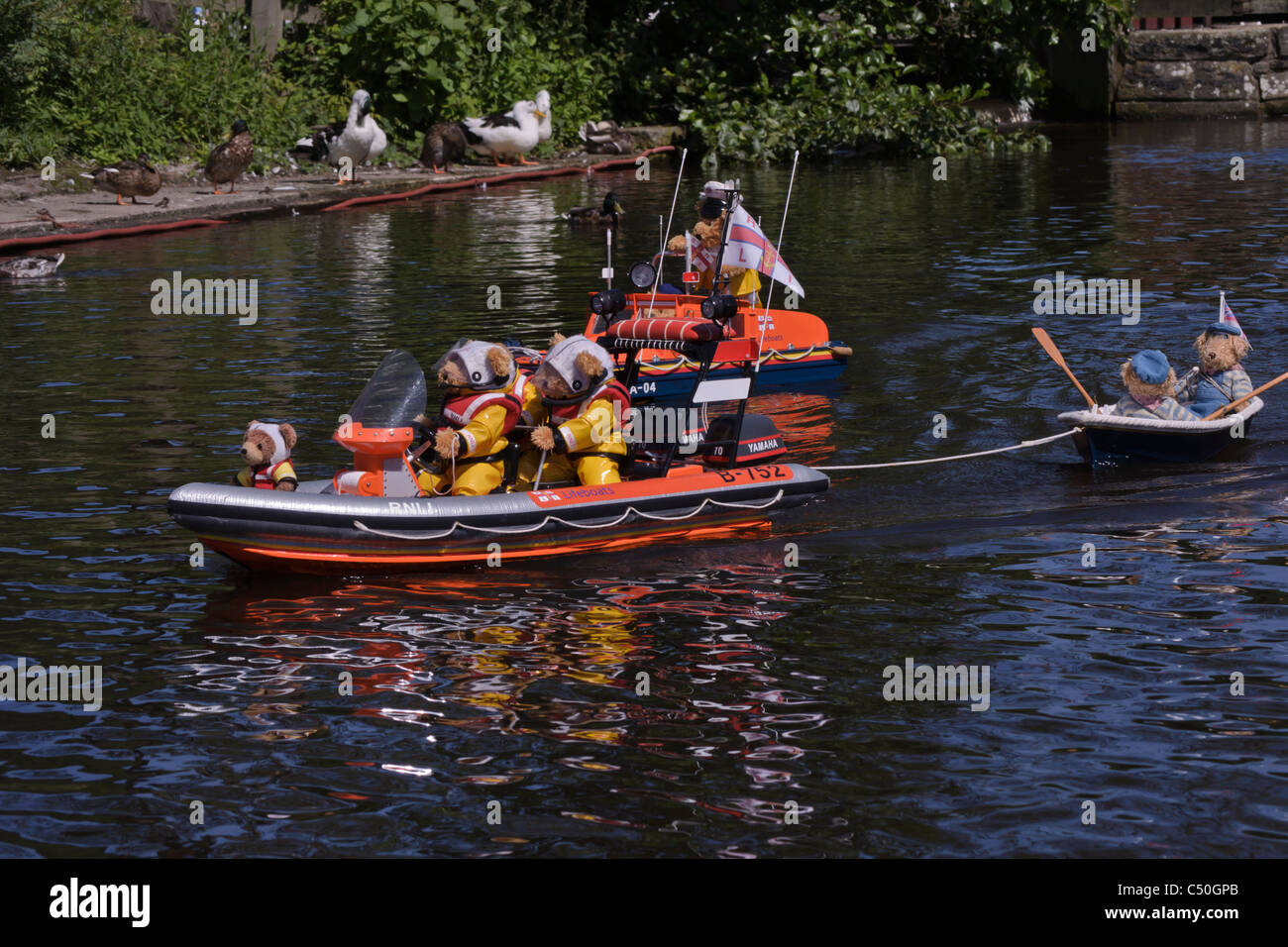 radio controlled scale model lifeboats in boating lake display with teddy bear crew etherow country park Stock Photo