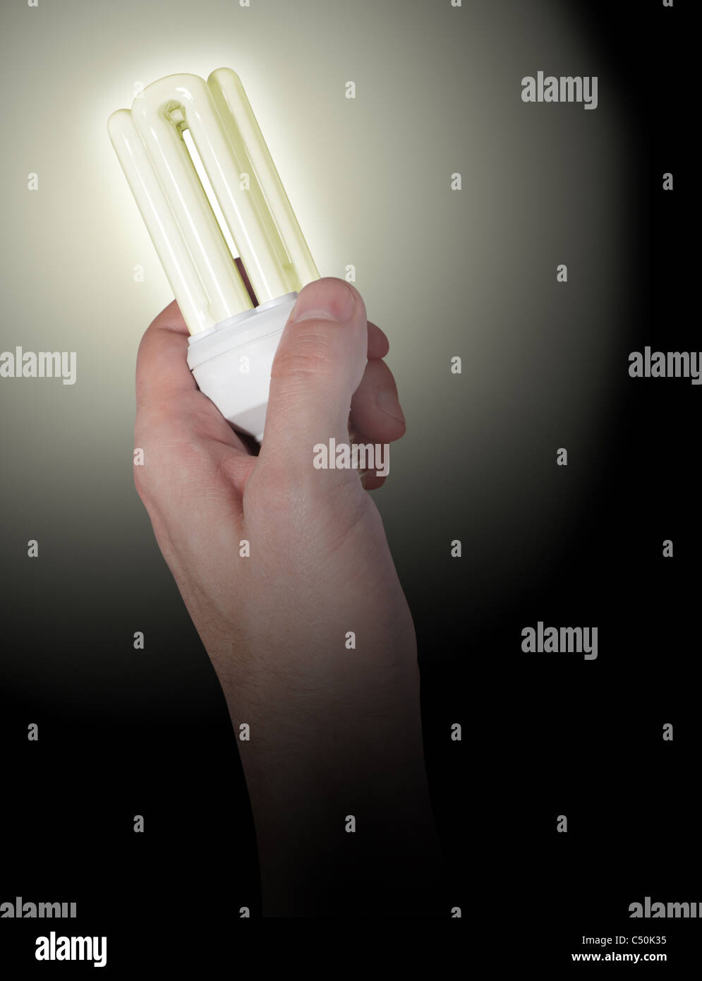 Glowing Energy Saving Bulb in Hand on Black Background Stock Photo - Alamy