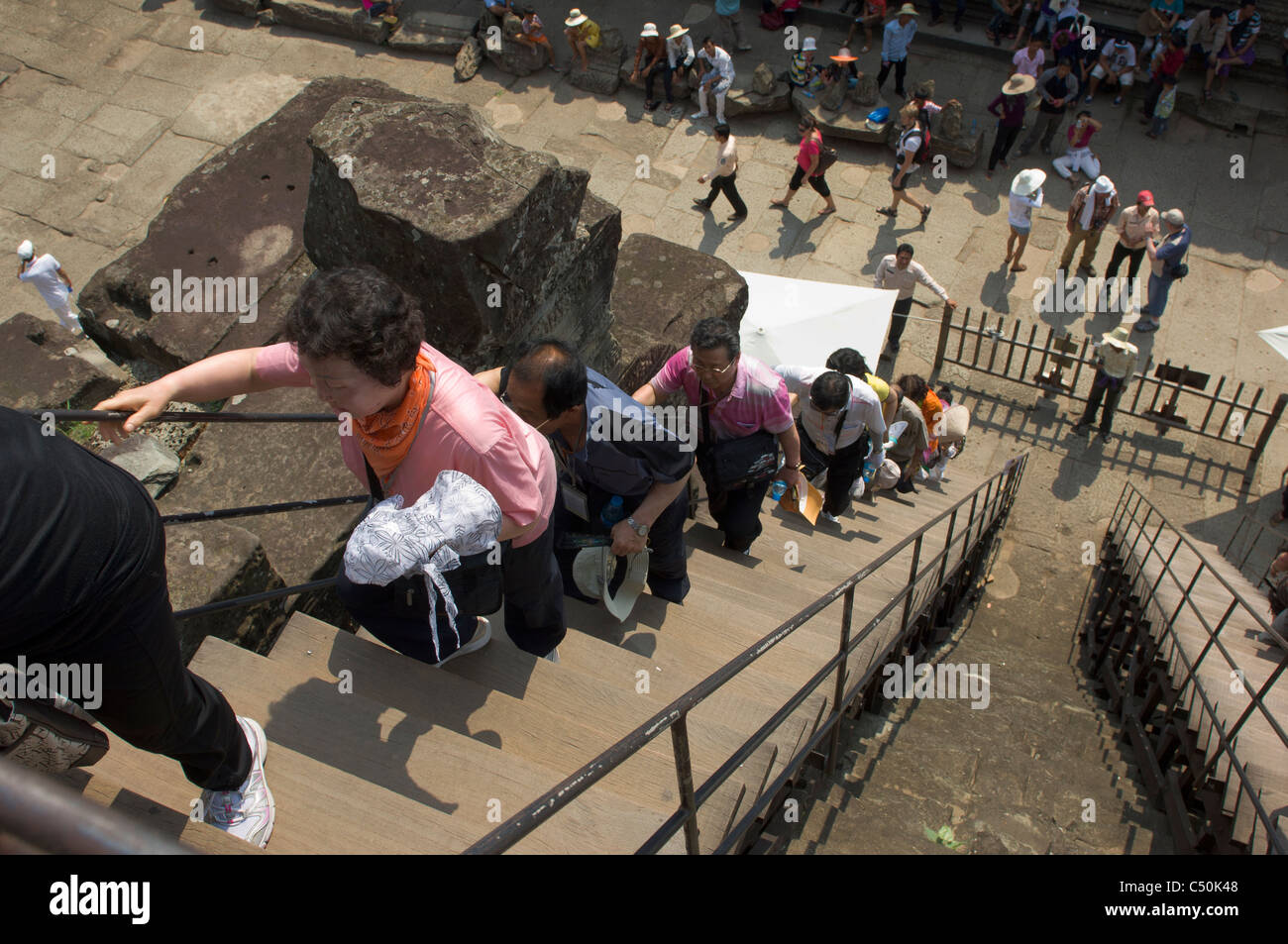 Tourists climbing up the steep steps leading to the third level of Angkor Wat, Angkor, Siem Reap, Cambodia Stock Photo