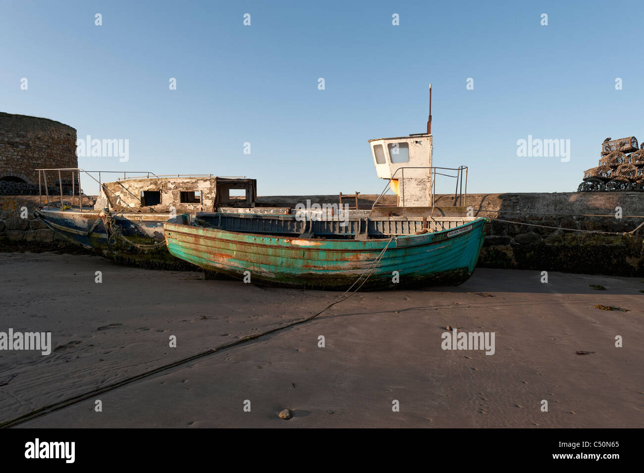 Old boats on the beach at Beadnell. Stock Photo