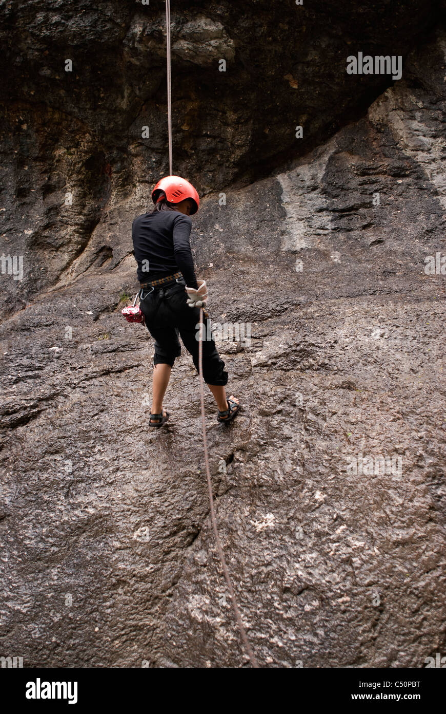 Girl rappelling down a cliff Stock Photo Alamy