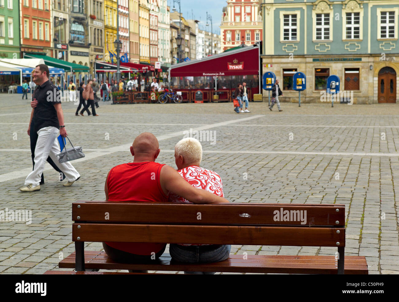 A couple sitting on a bench in the market square, Wroclaw, Poland Stock Photo