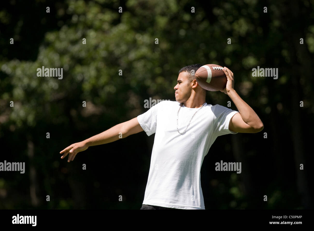 A young adult throwing a football outside Stock Photo Alamy