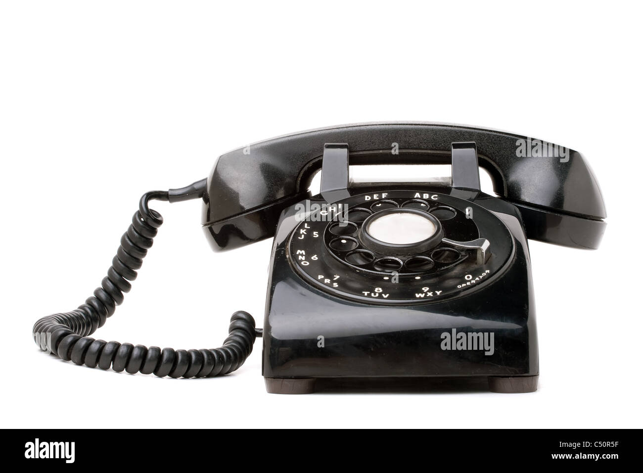 An old black vintage rotary style telephone isolated over a white background. Stock Photo