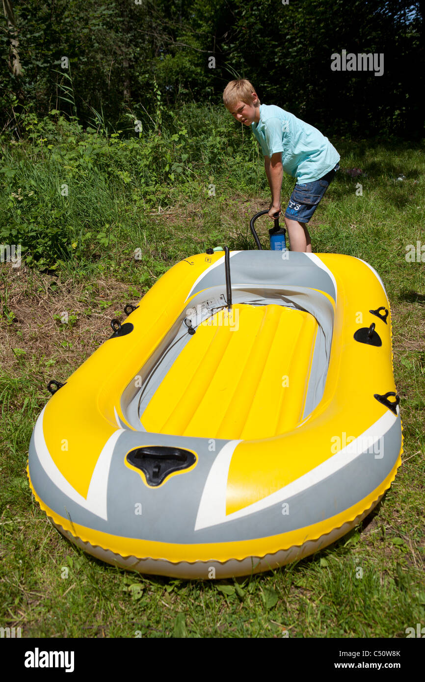 young boy inflating his rubber boat Stock Photo Alamy