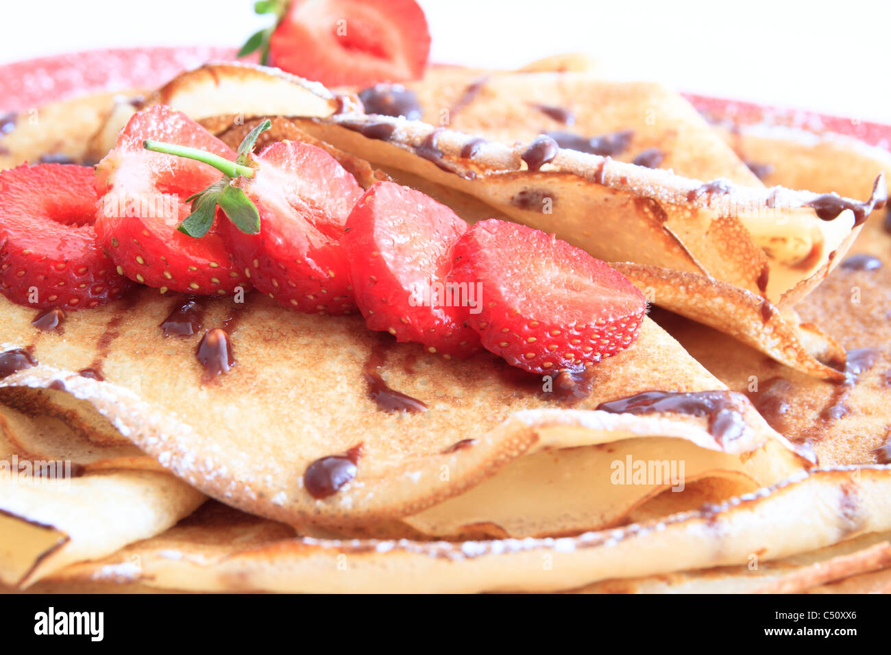 pancakes with strawberries on red plate Stock Photo