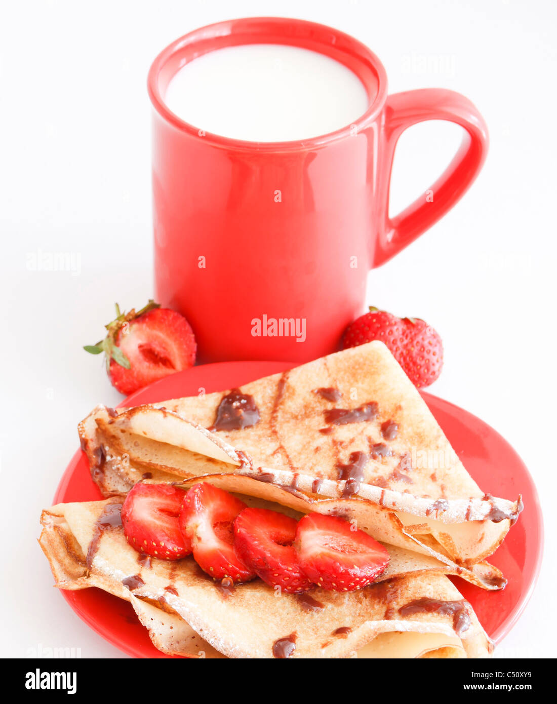 cup of milk and strawberries pancakes with chocolate Stock Photo