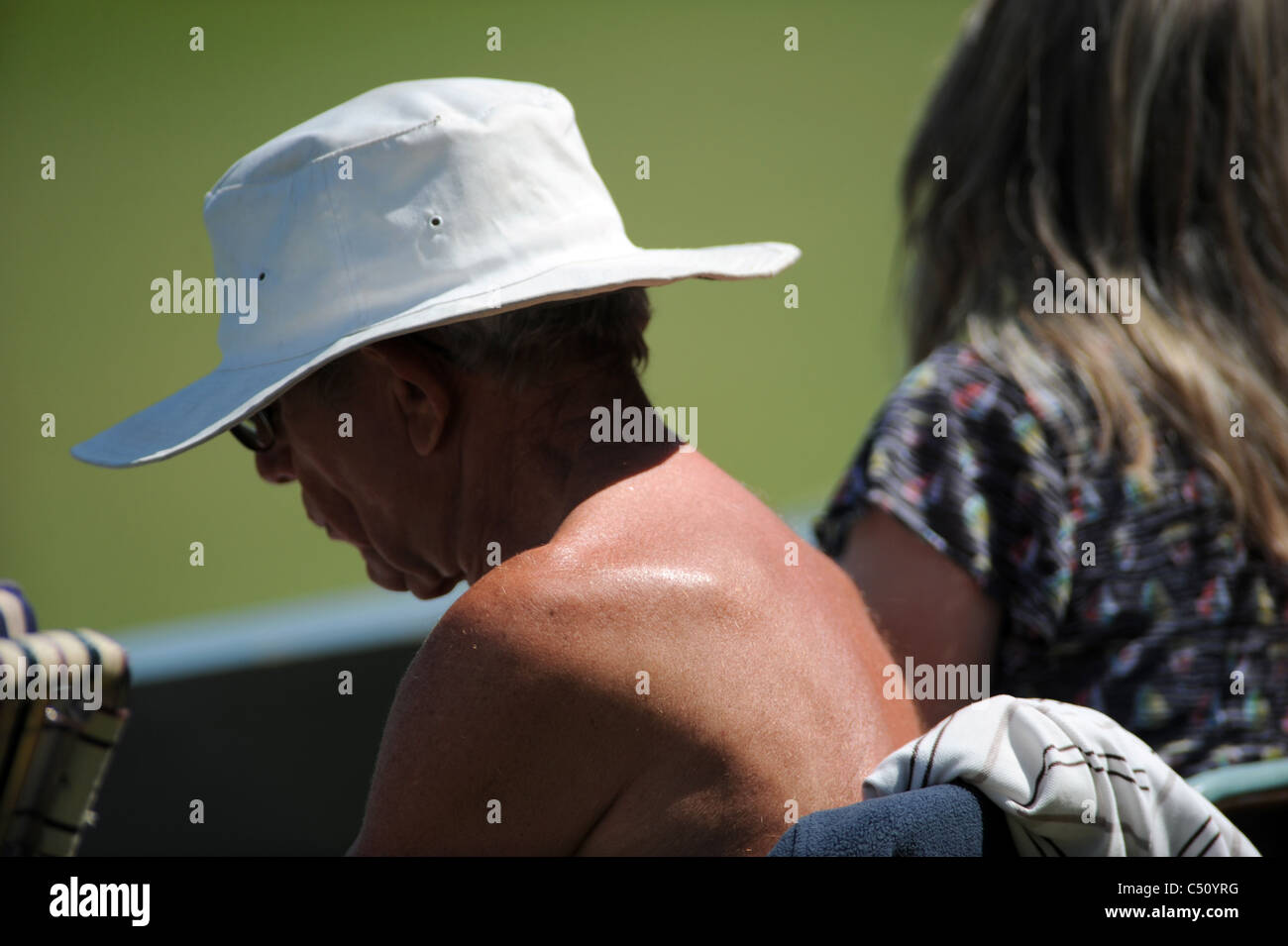 Man watching cricket with his shirt off getting sunburnt on shoulders UK Stock Photo