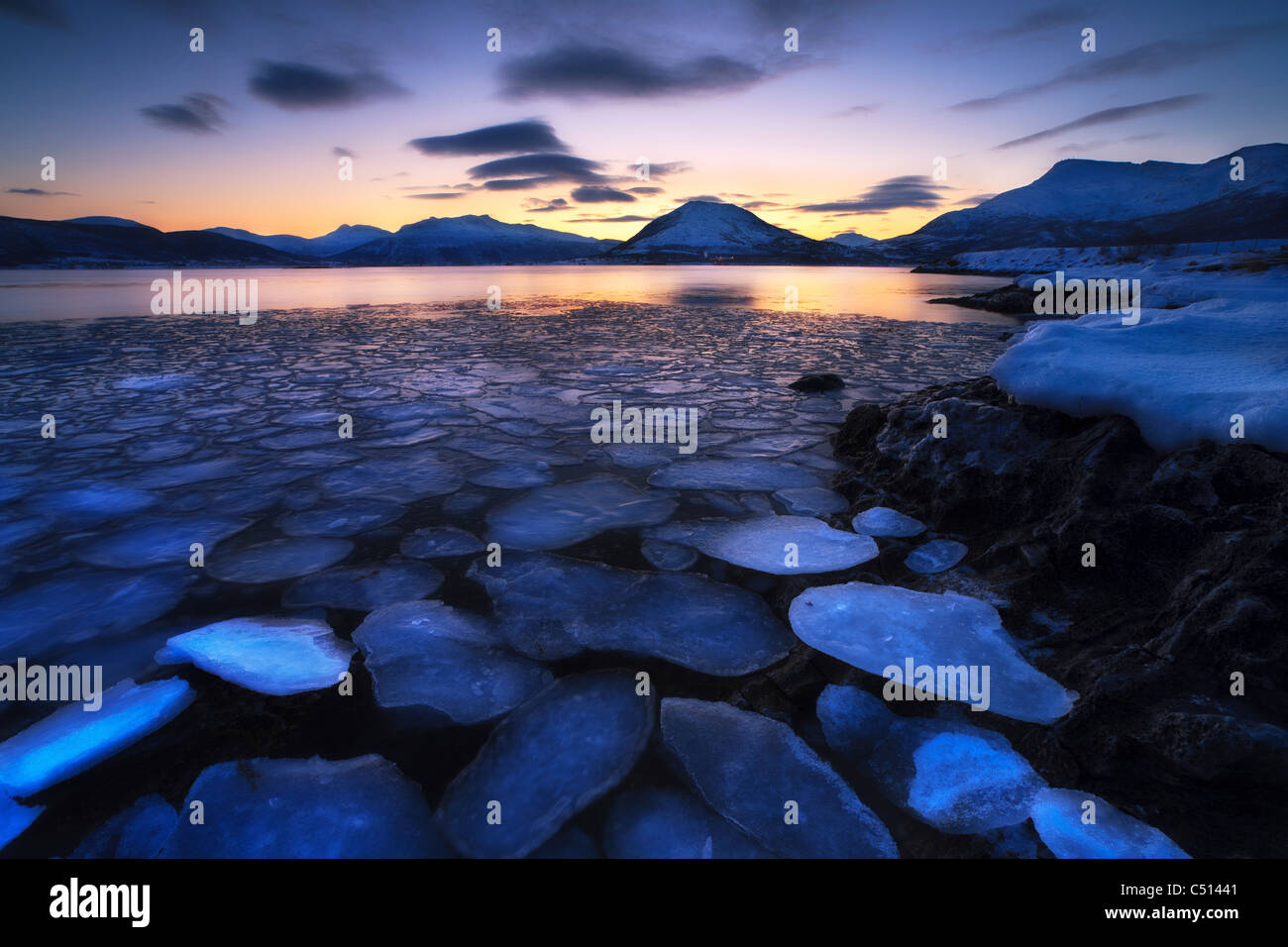 Ice flakes drifting against the sunset in Tjeldsundet strait, Troms County, Norway. Stock Photo