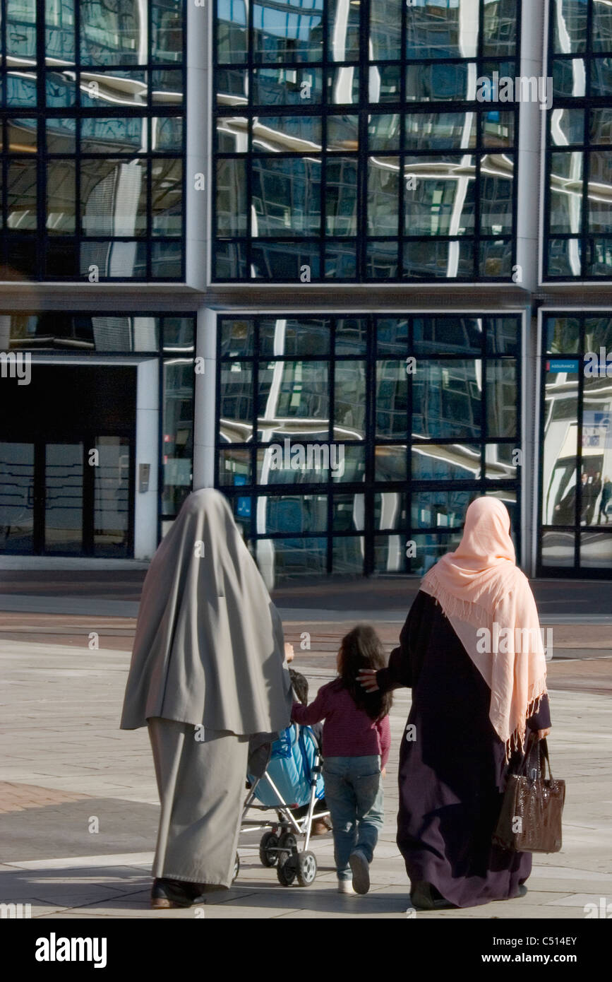 Women wearing hijabs walking with children Stock Photo