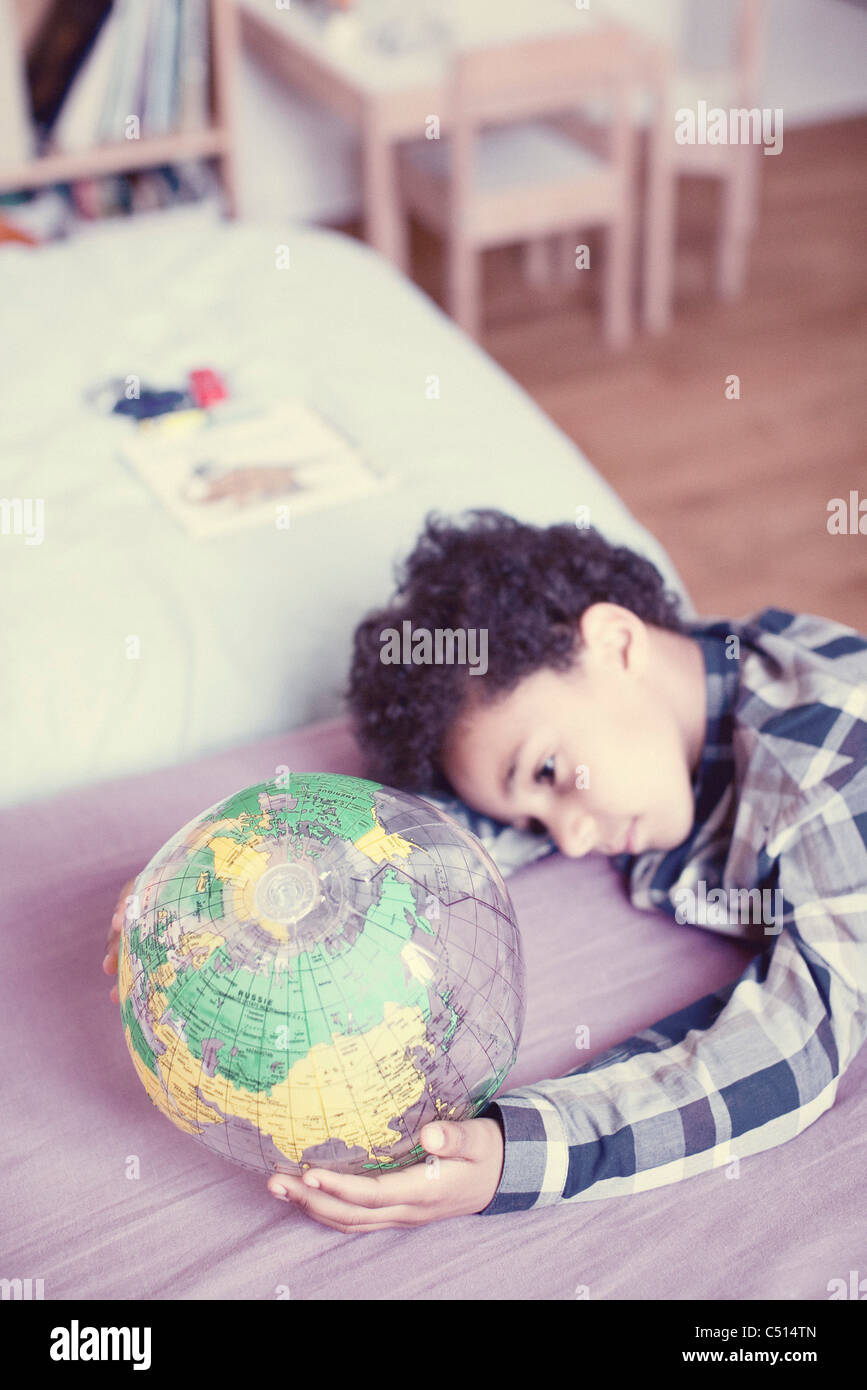 Little boy contemplating at inflatable globe Stock Photo