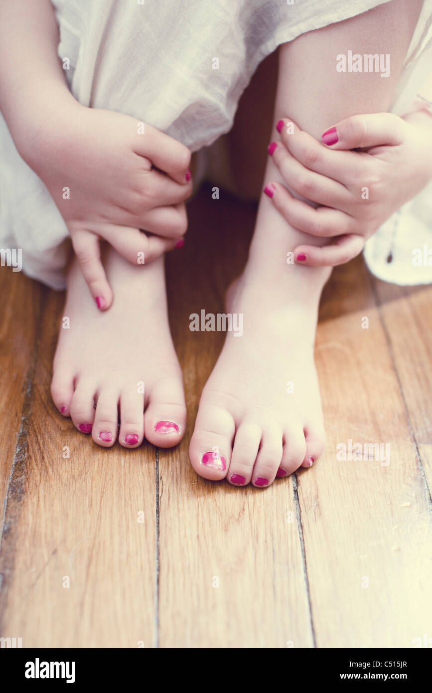 Little girl hugging knees, low section Stock Photo - Alamy