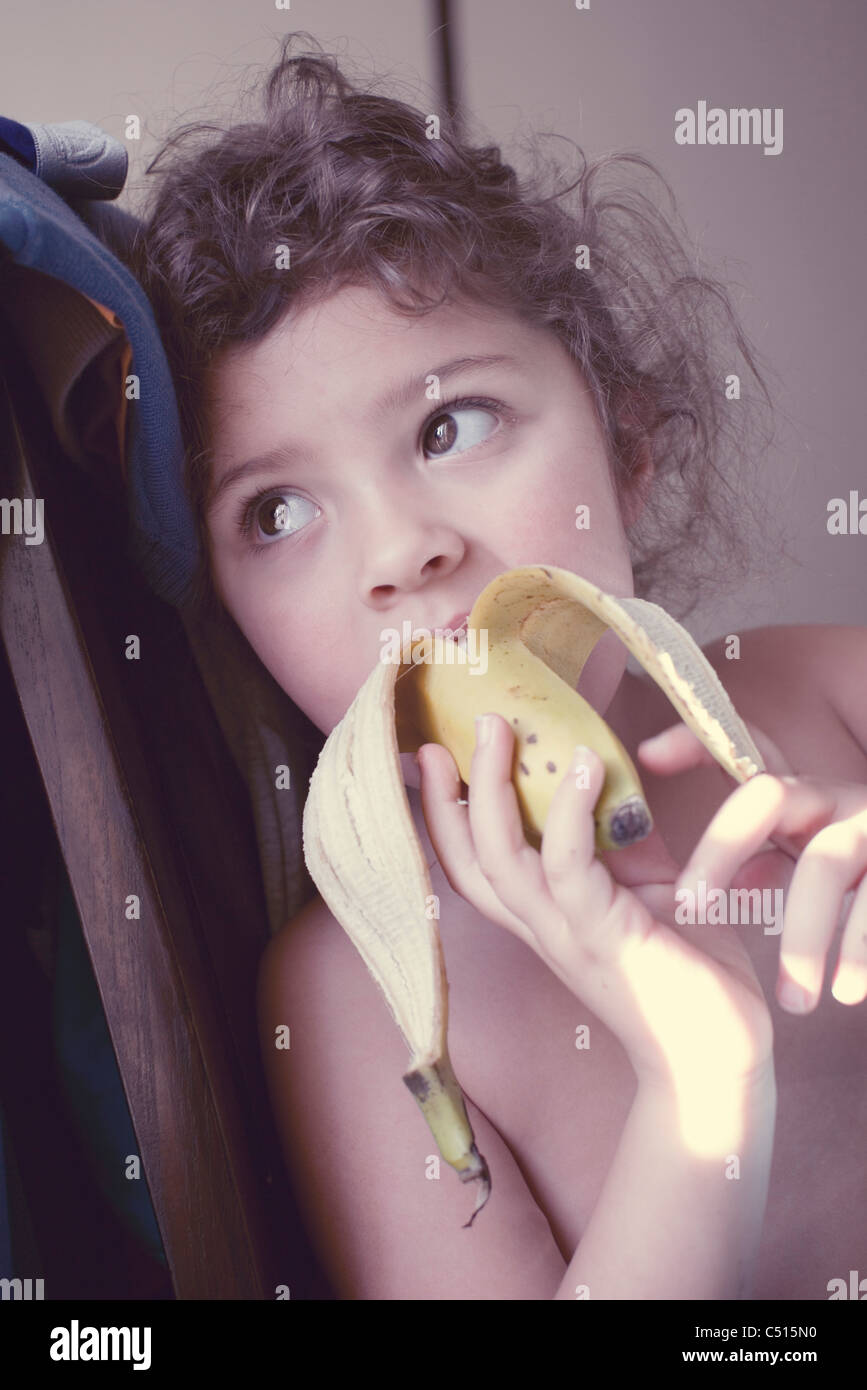 Little girl eating banana Stock Photo