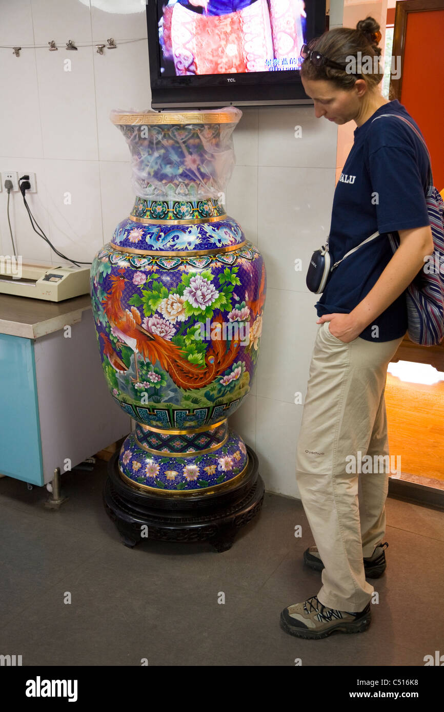 Adult woman / female tourist with large / big cloisonne vase display / for sale in gift shop at the Summer Palace Beijing, China Stock Photo