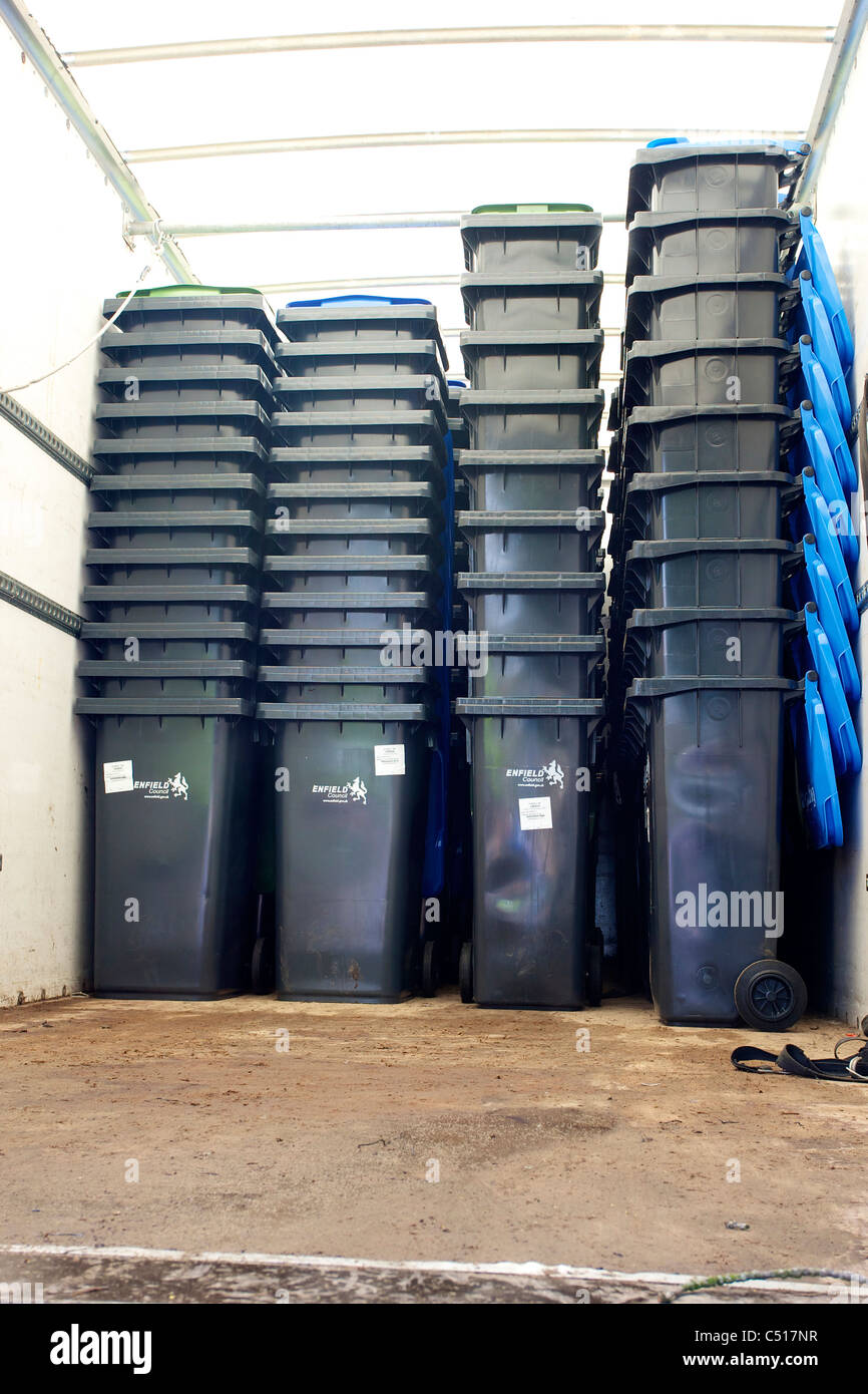 Wheeled bins on the back of a truck being made ready for delivery to