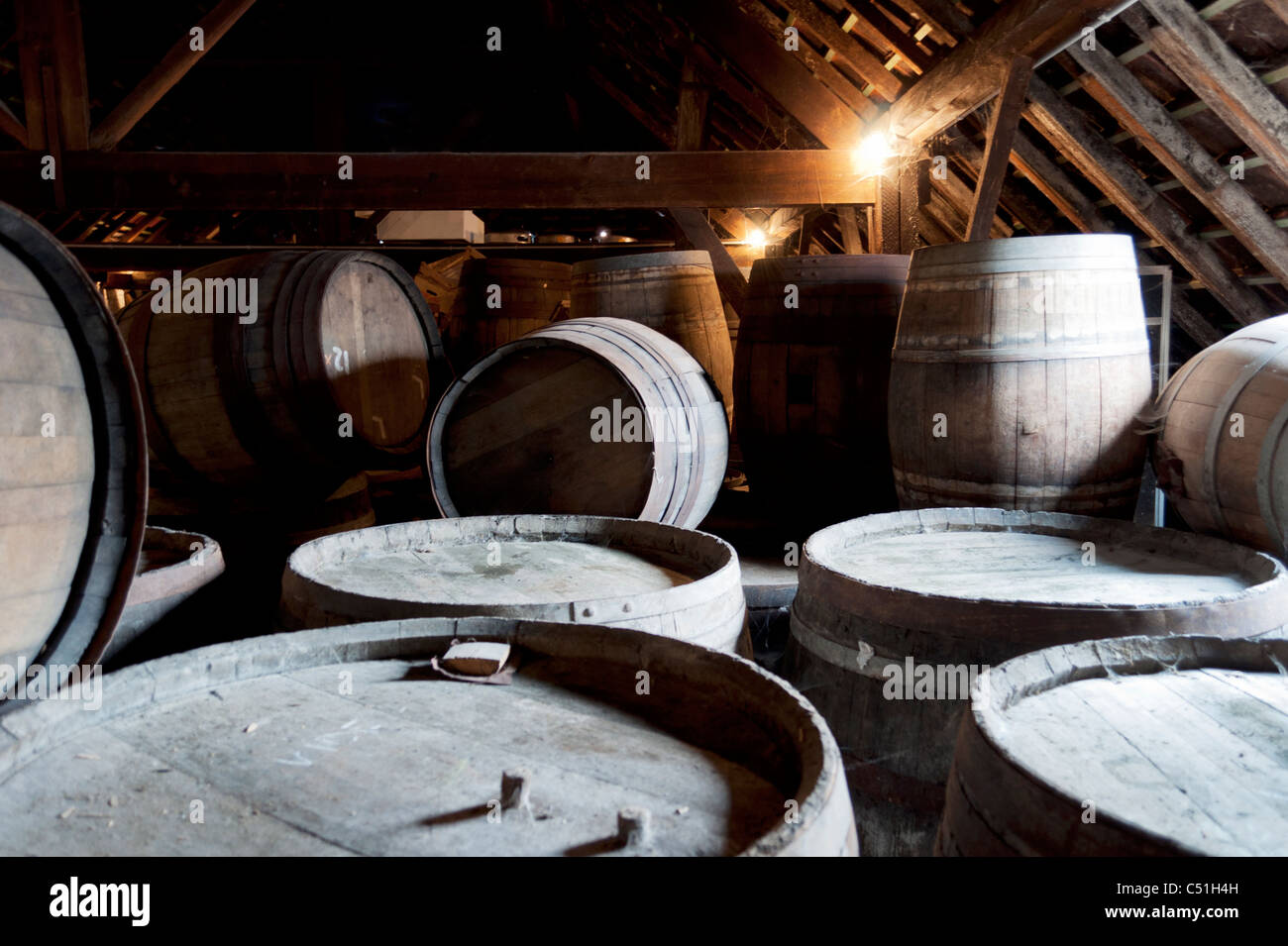 Barrels containing beer stack against each other in the Cantillon brewery in Brussels, Belgium. Stock Photo