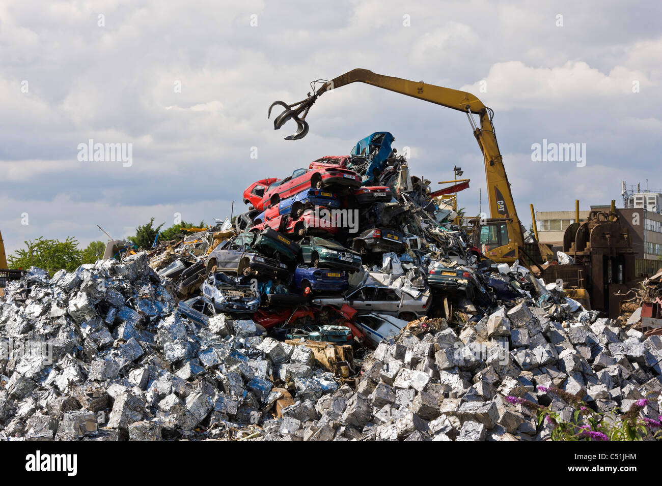 Unwanted old cars scrapped and crushed into cubes at recycling
