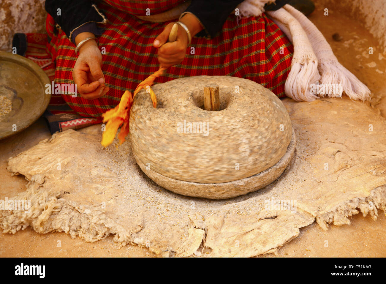Africa, North Africa, Tunisia, Matmata, Troglodyte Pit Home, Berber Woman Grinding Grain Stock Photo