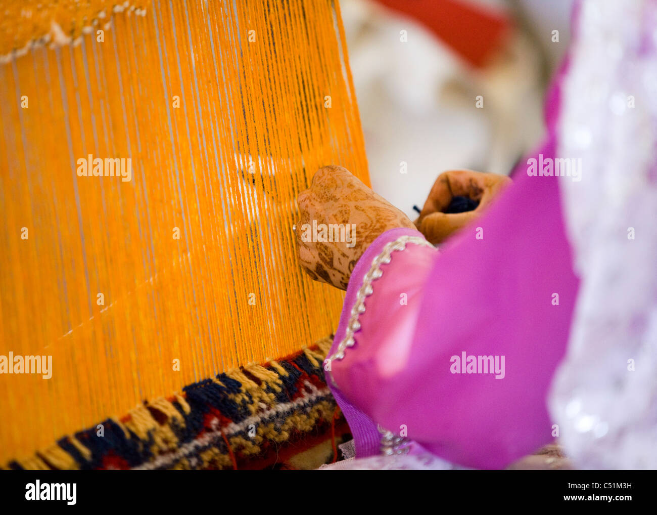 Close Up Of Hands Of An Moroccan Woman Weaving Using A Hand Loom Stock