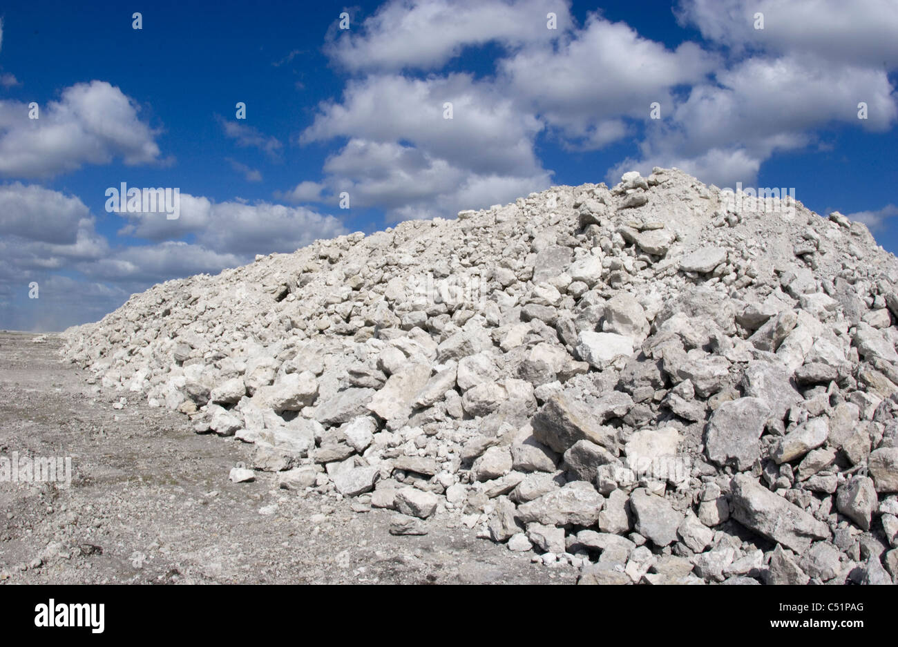 pile of rock under blue sky with puffy clouds Stock Photo - Alamy