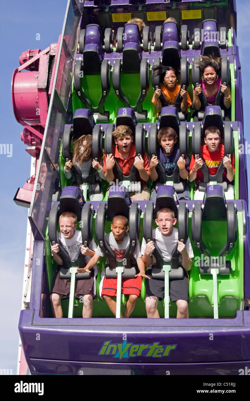 Teens enjoying theme park ride Stock Photo