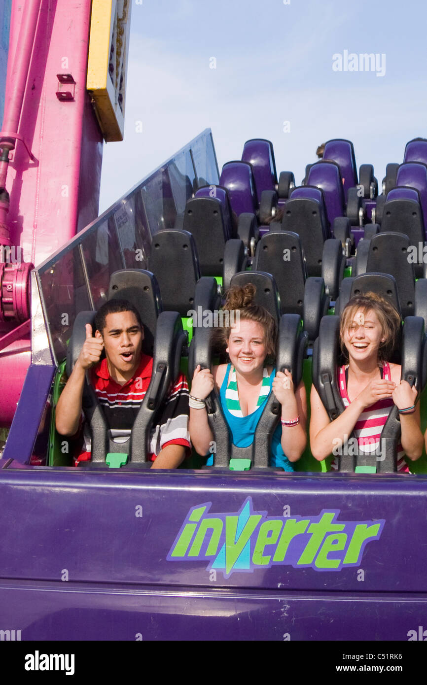 Teens riding theme park ride Stock Photo