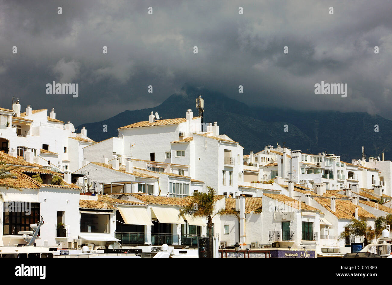 A dark sky over the mountains at Puerto Banus Spain Stock Photo
