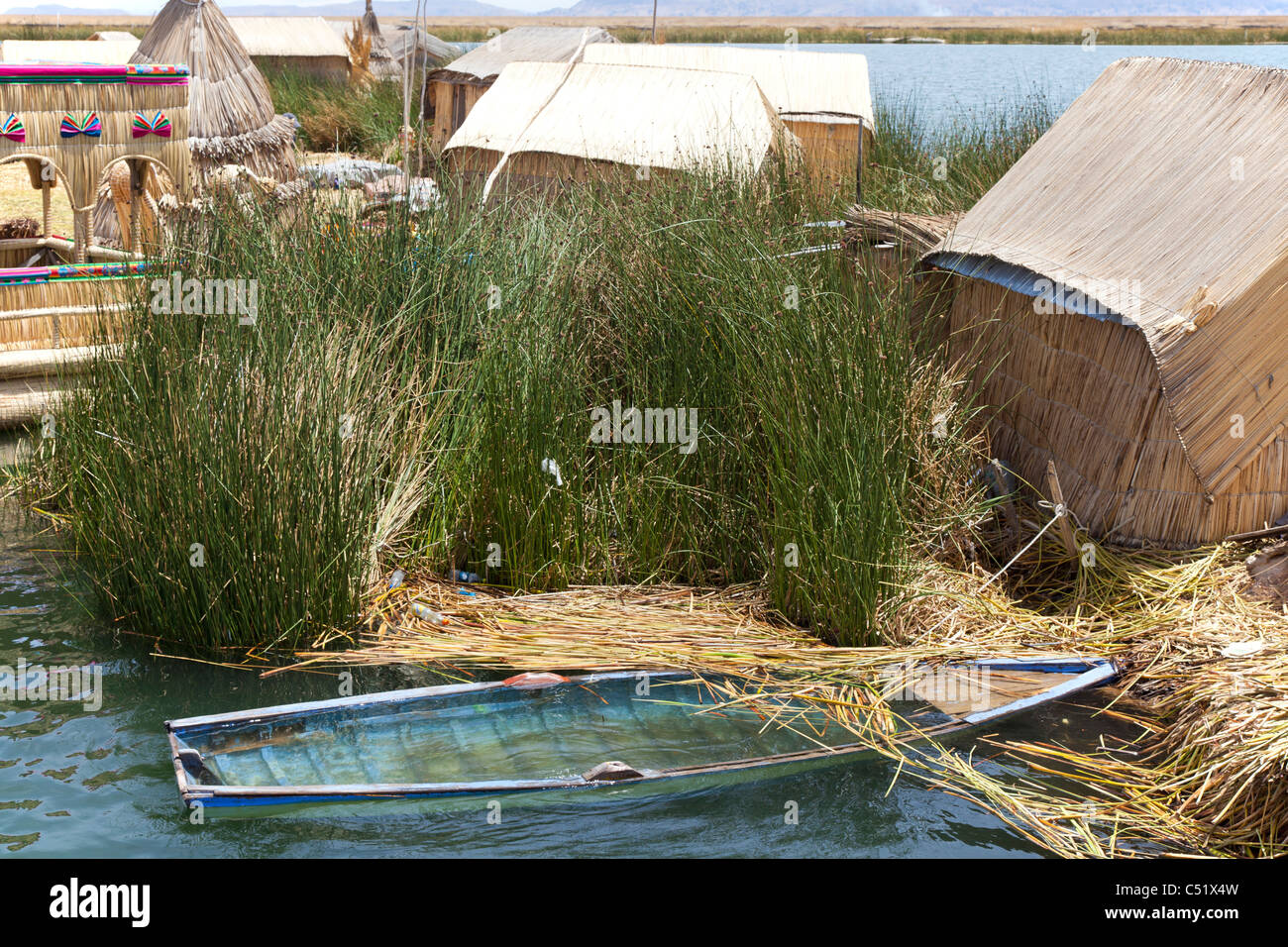 Partially submerged blue rowing boat on the Uros Islands, Lake Titicaca, Peru Stock Photo