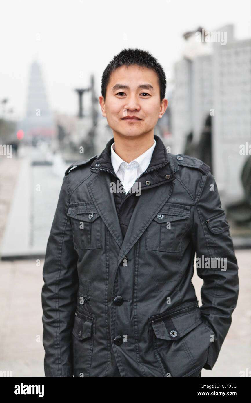 Portrait of a Young Chinese Man Standing in the Street with Hand in Pocket, Xian, China Stock Photo