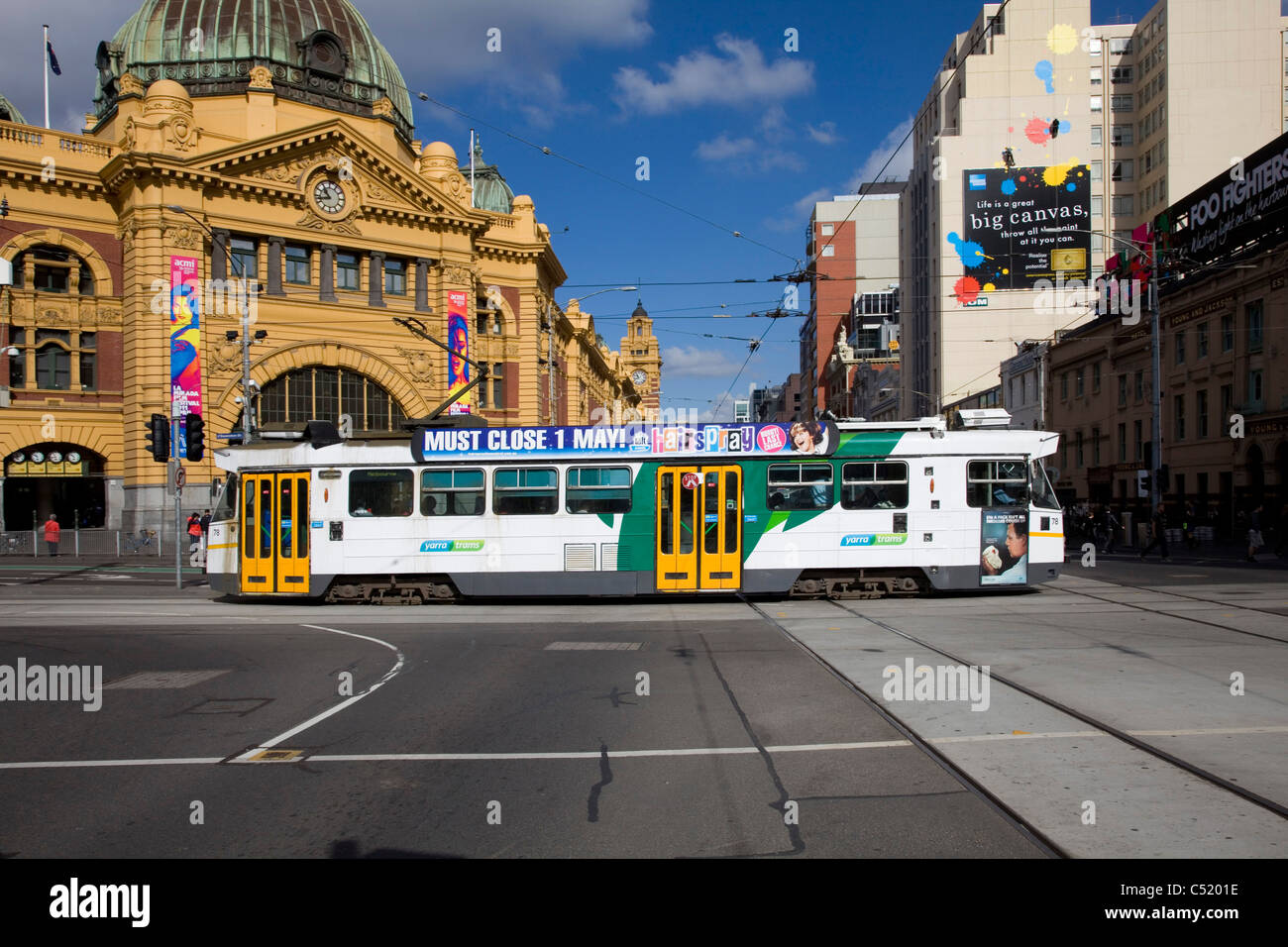 Electric Tram in Melbourne, Victoria. Crossing the intersection alongside Flinders Street Station Stock Photo