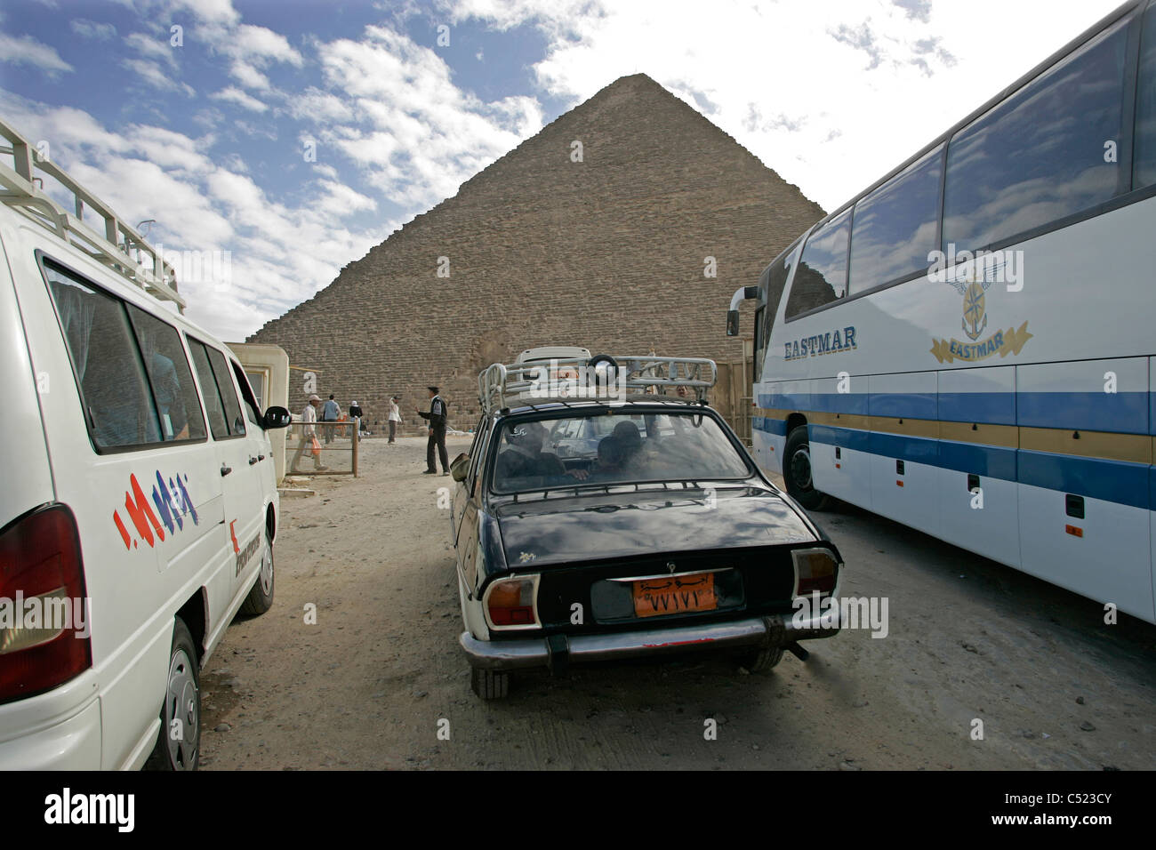 Buses and car parked next to the Great Pyramid of Khufu on the Giza plateau, Egypt Stock Photo