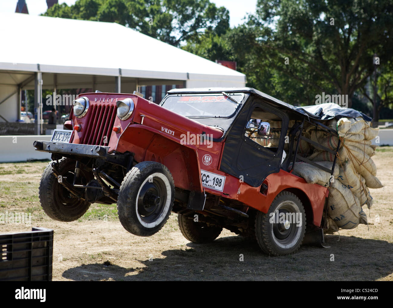 Overloaded Willys M38 Jeep with its front wheels up in the air Stock Photo