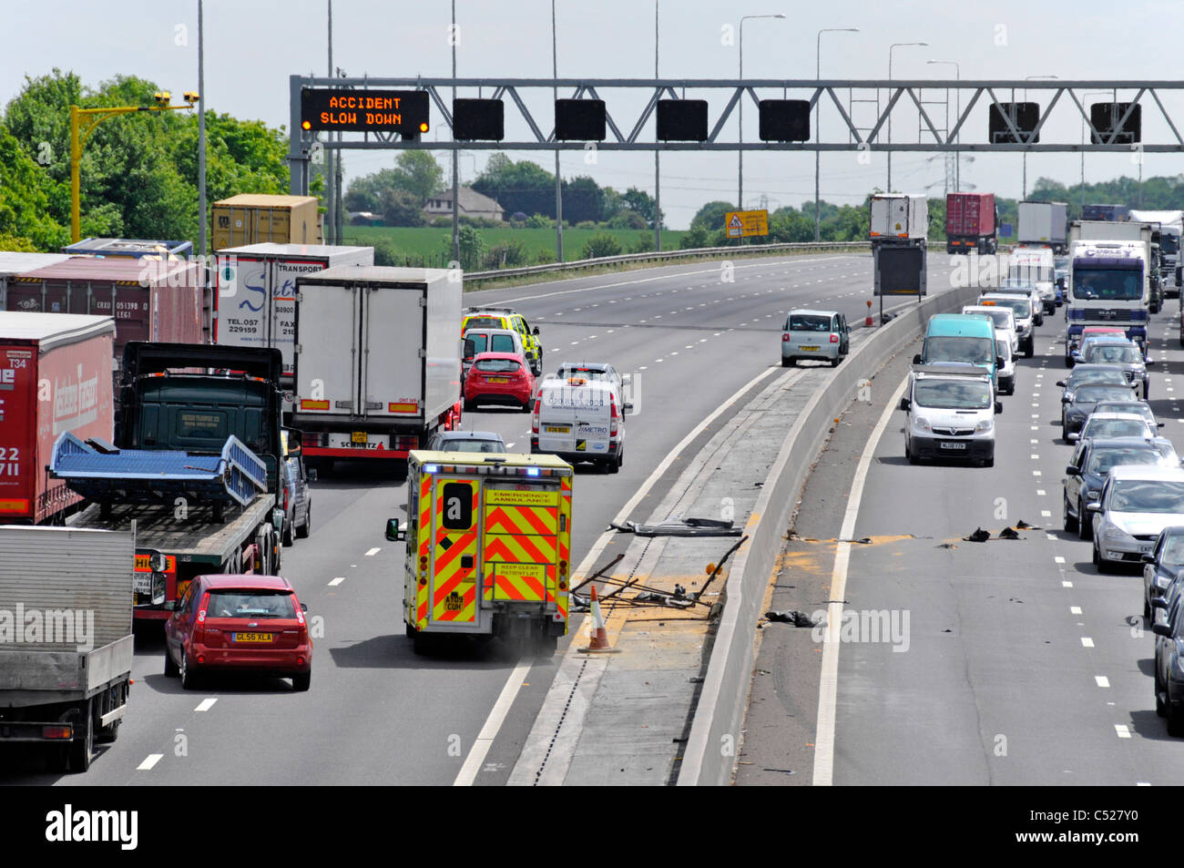 M25 motorway delays in both directions after crashes in each carriageway ambulance avoiding debris to reach accident M25 motorway Essex England UK Stock Photo