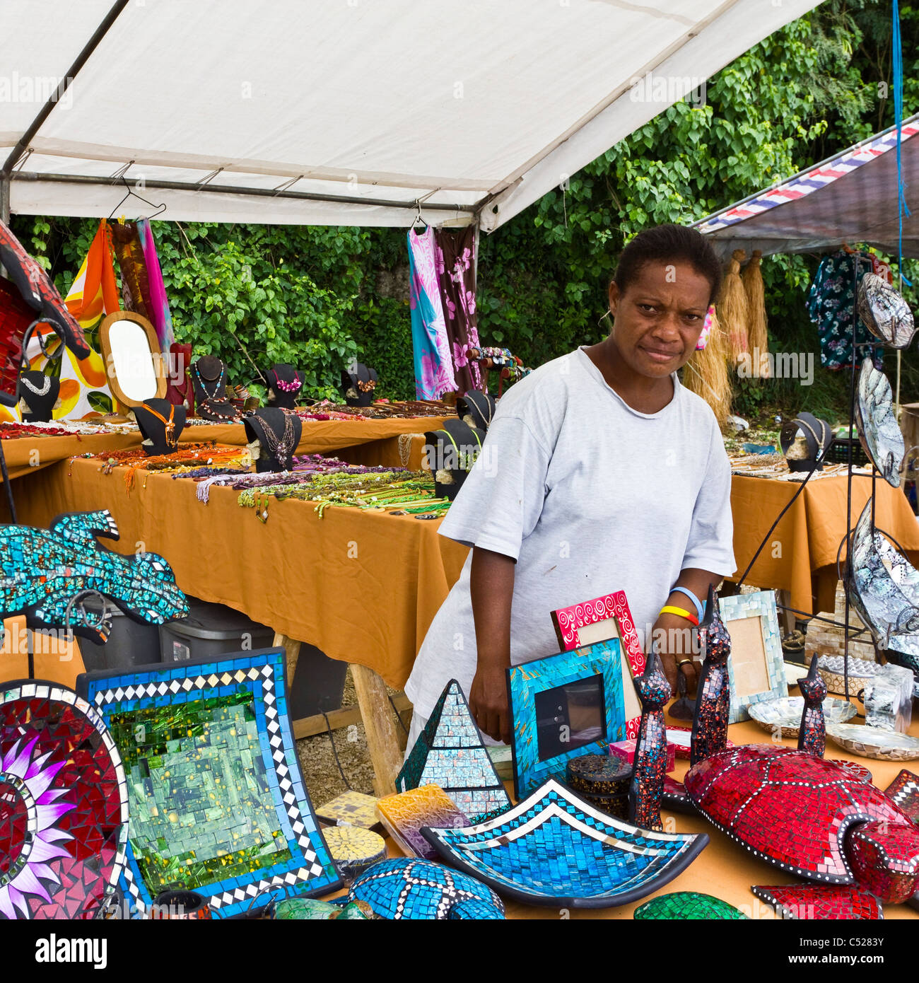 Female market stall holder selling decorative and traditional craft goods Stock Photo