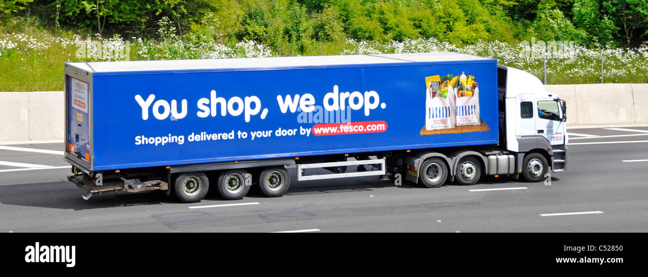 Side view of hgv supermarket food supply chain store grocery delivery lorry truck with trailer advertising Tesco food business driving on UK motorway Stock Photo