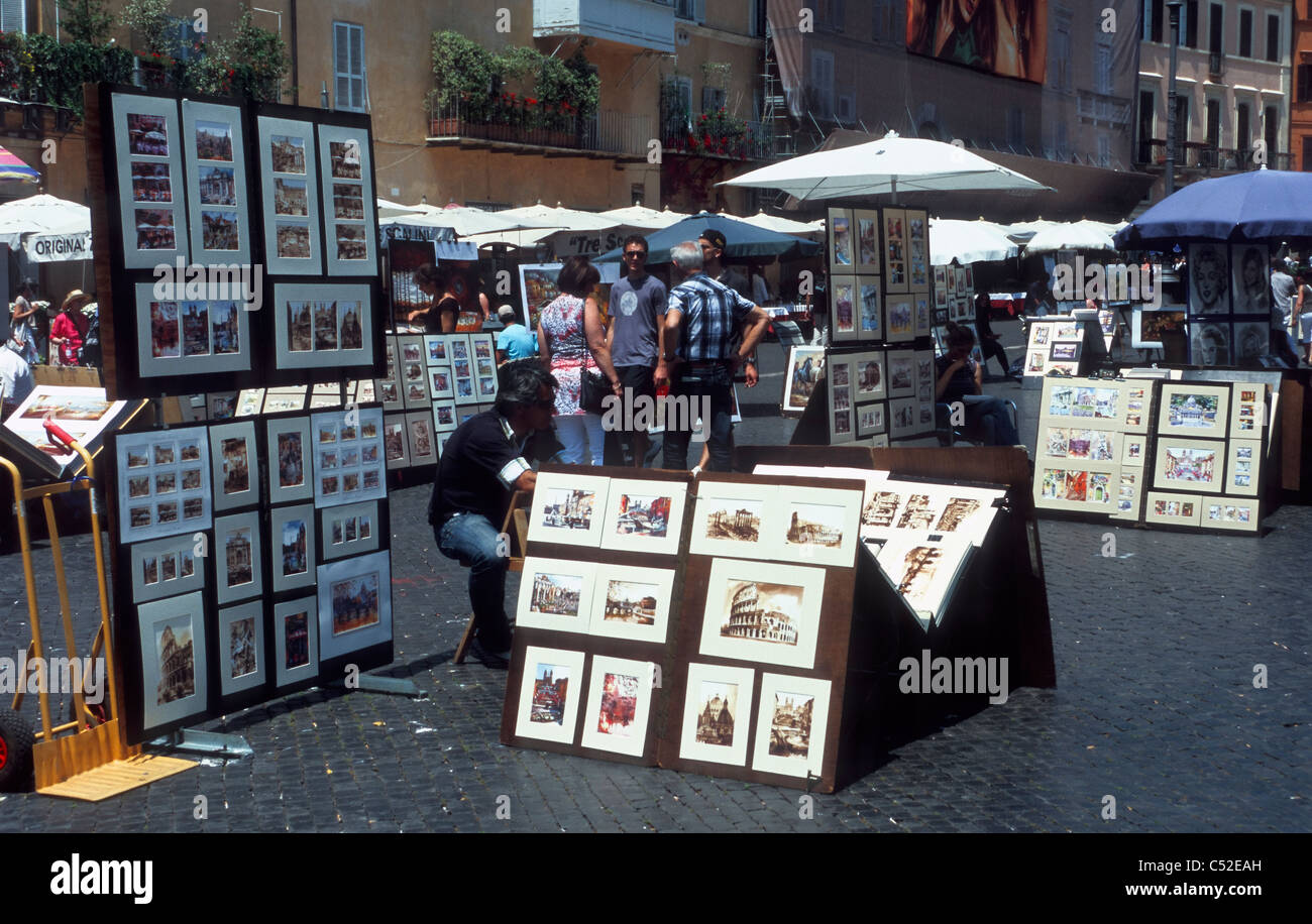 An art seller is showing artworks with Roman subjects, Piazza Navona, Rome, Latium, Italy Stock Photo