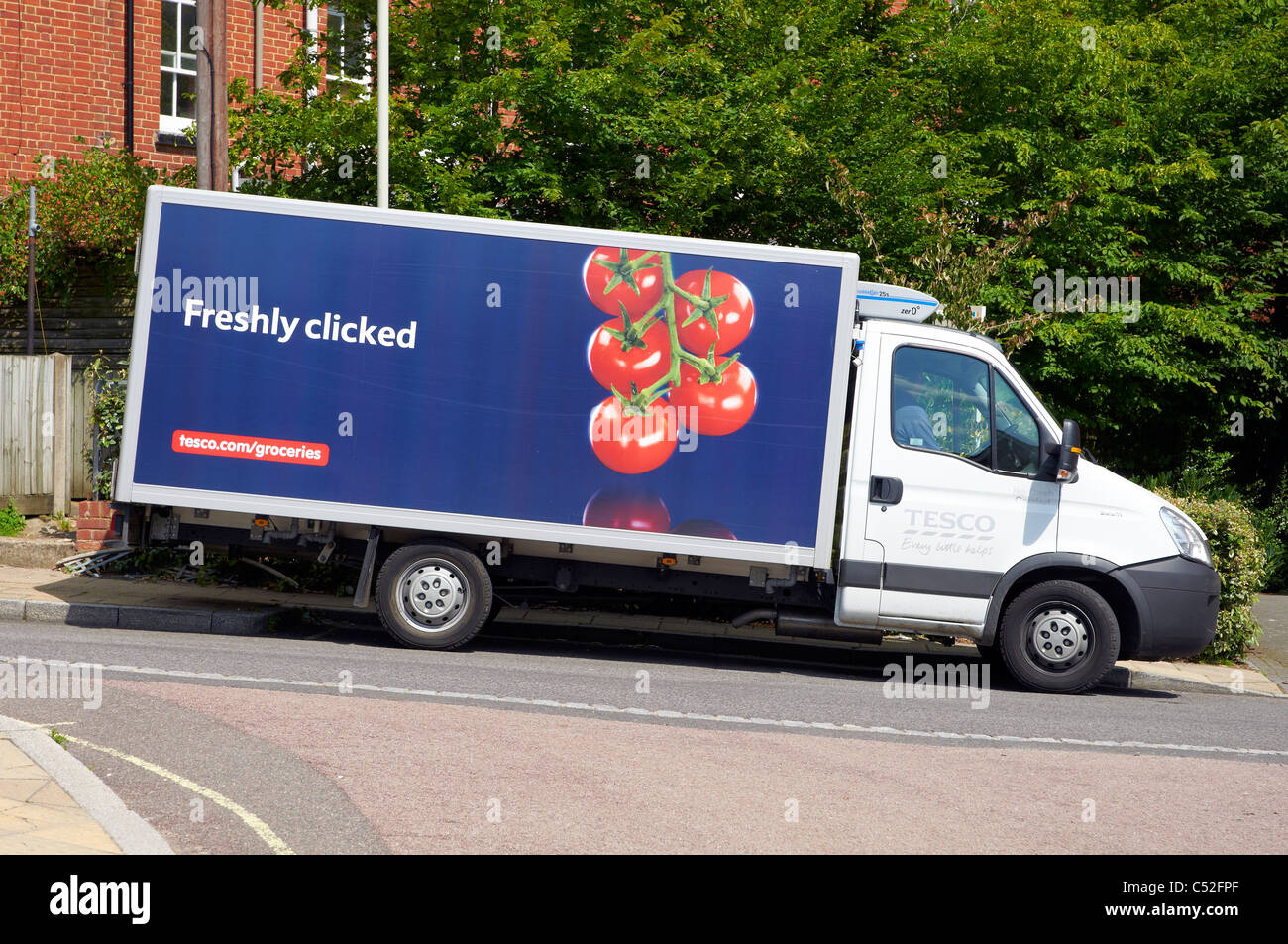 Tesco home delivery van parked on a steeply sloping street in Winchester, Hampshire after delivering groceries to a nearby house Stock Photo