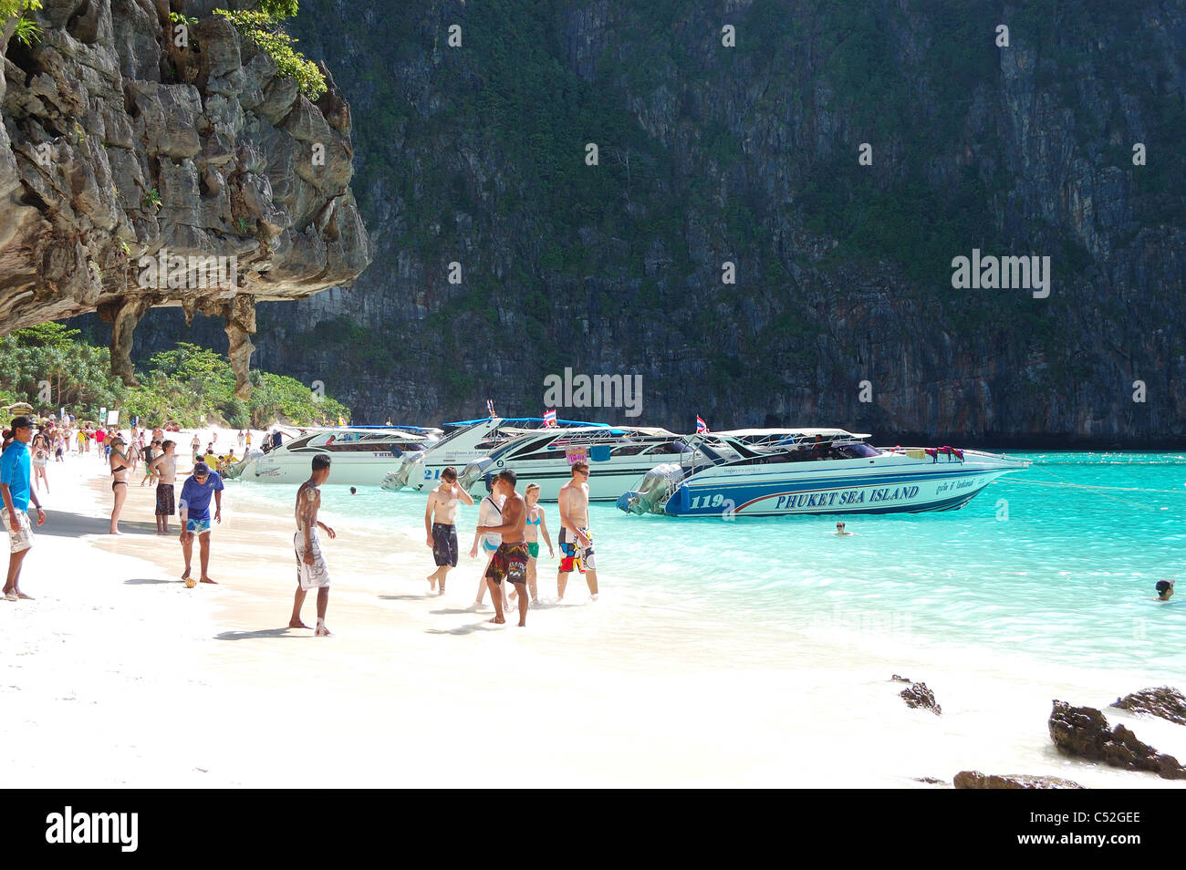 Beach with tourists and motor boats on turquoise water of Maya Bay lagoon, Koh Phi Phi island, Thailand Stock Photo