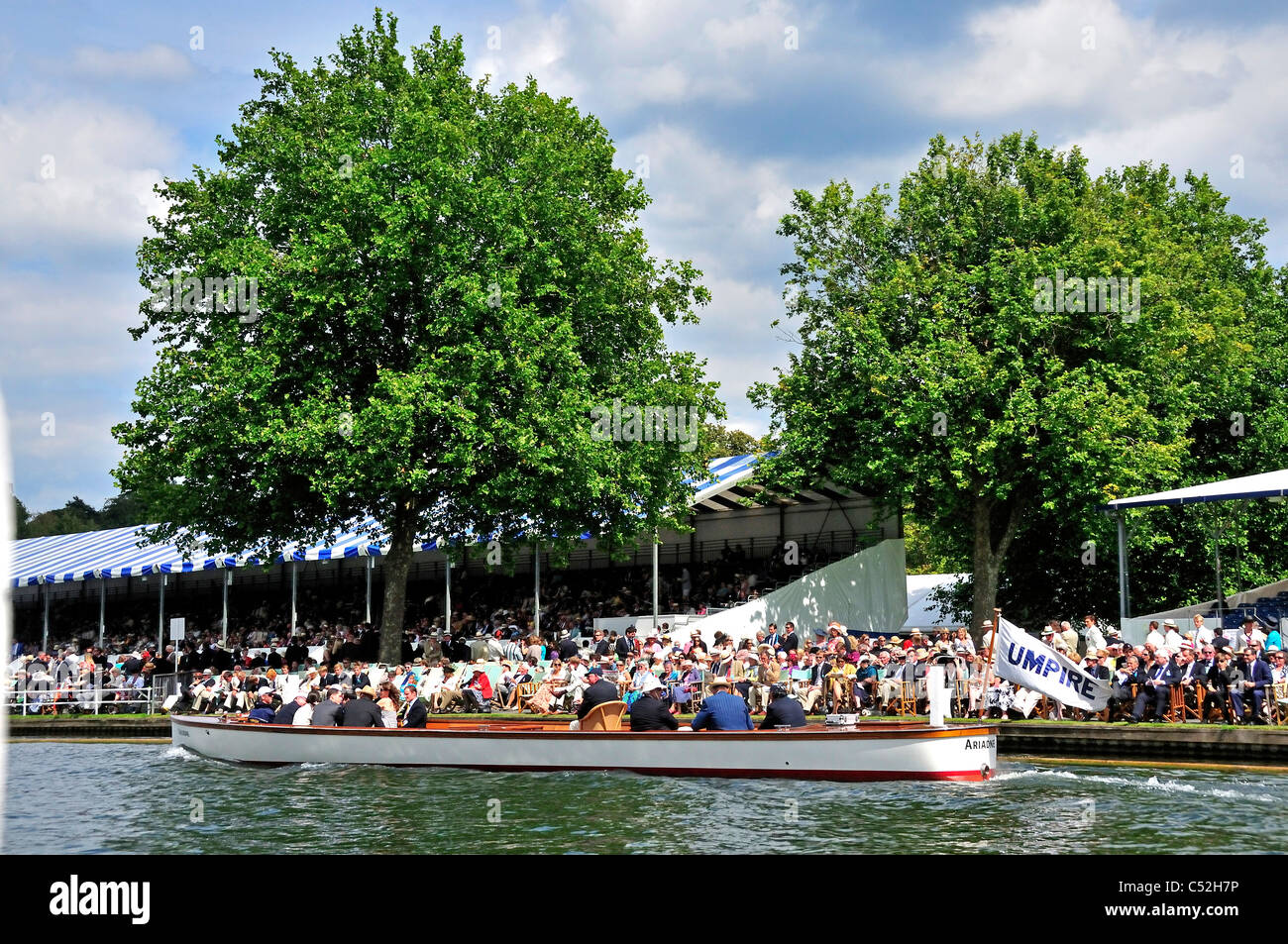 View of Henley Royal Regatta Stewards's Enclosure with umpire launch travelling to the start, Henley-on-Thames, Oxfordshire, UK Stock Photo
