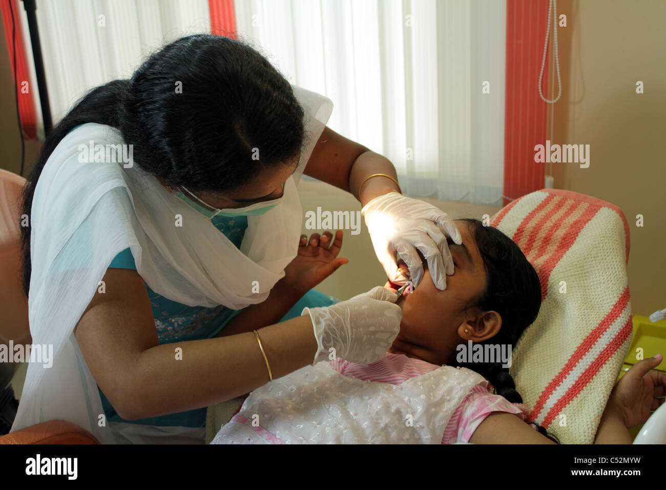 A dentist in India extracting an 8 year old girl's tooth Stock Photo - Alamy