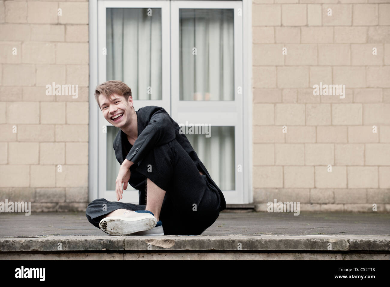 man sitting outside office smiling Stock Photo