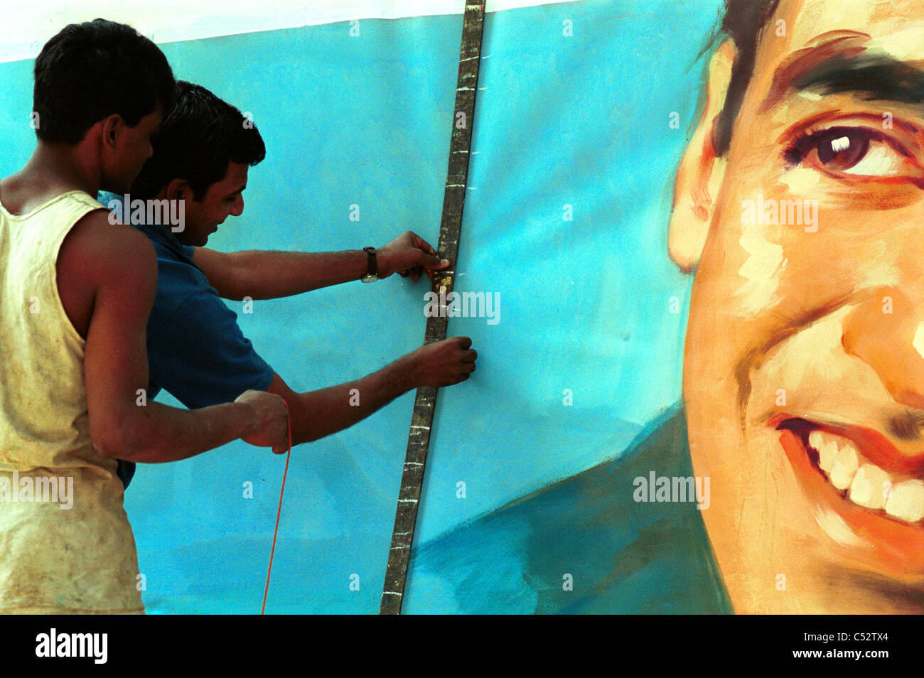 INDIA, Mumbai Bombay, Ellora Arts film hoarder, artists paint large wall posters as advertisement for new Bollywood movie releases at cinemas Stock Photo