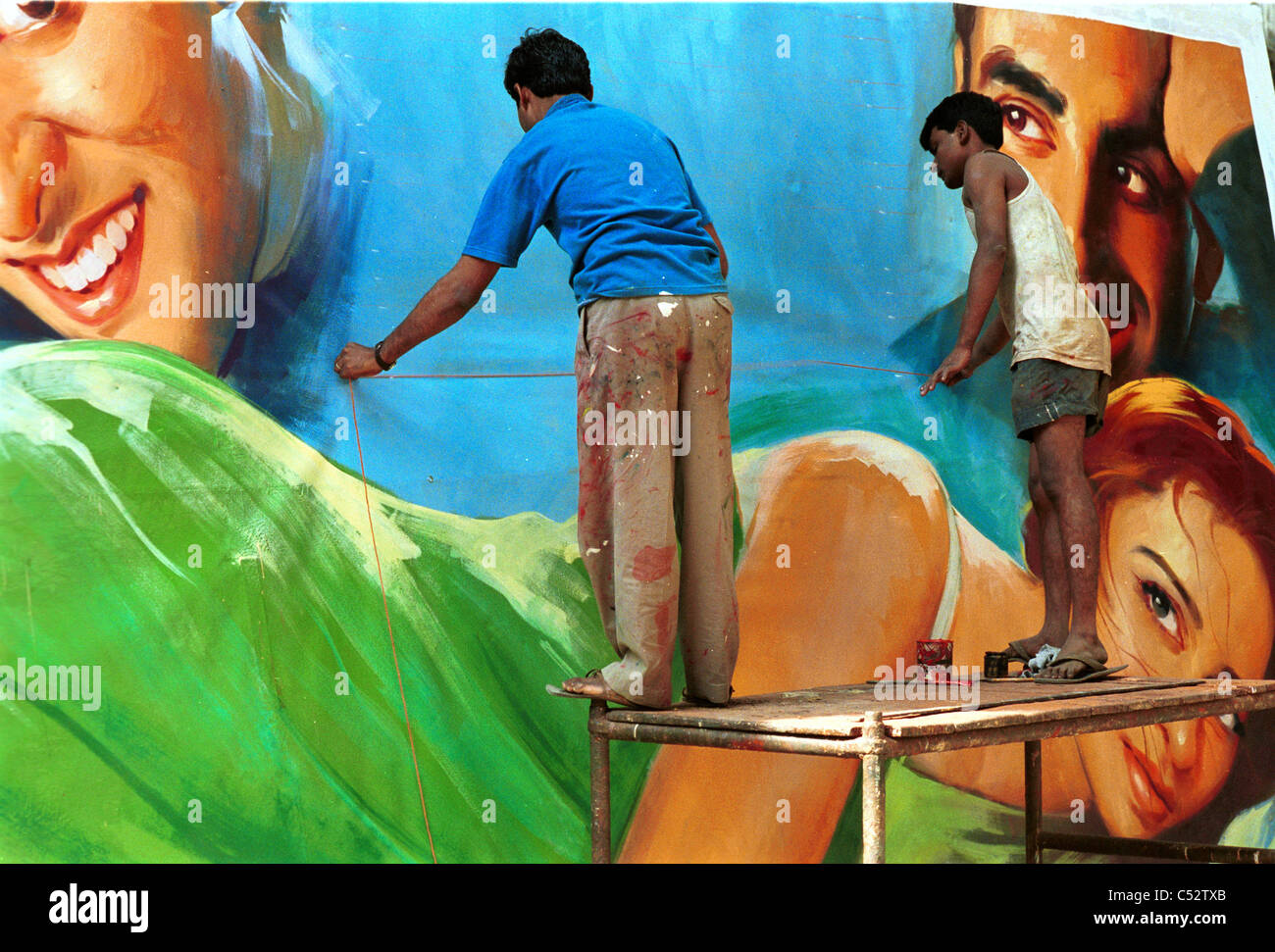 INDIA, Mumbai Bombay, Ellora Arts film hoarder, artists paint large wall posters as advertisement for new Bollywood movie releases at cinemas Stock Photo