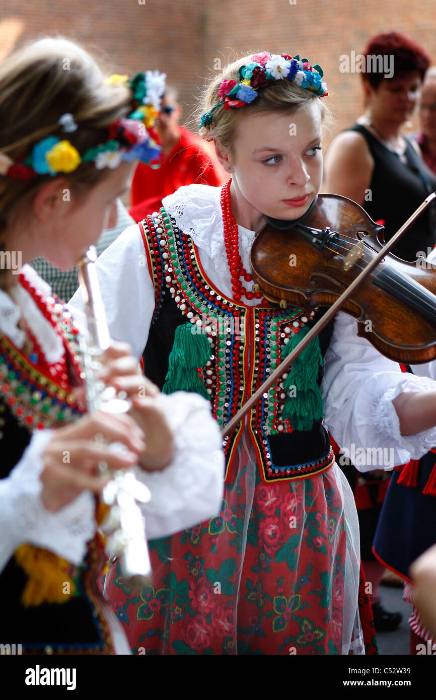 A group of children in traditional Krakow style folklore costumes during a music performance. Stock Photo