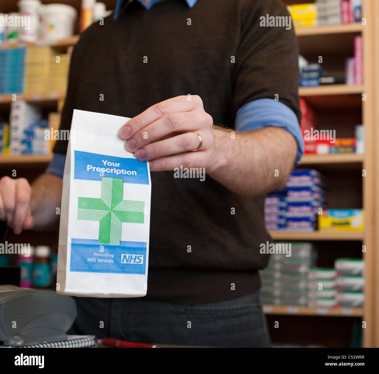 pharmacist handing over prescription at chemist Stock Photo