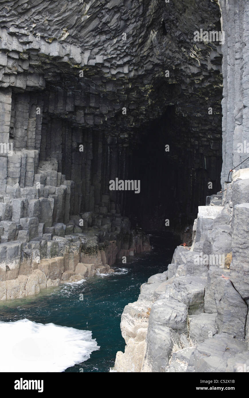 Fingals Cave entrance on Staffa with foam surf from the rising tide as it surges in and out. Stock Photo