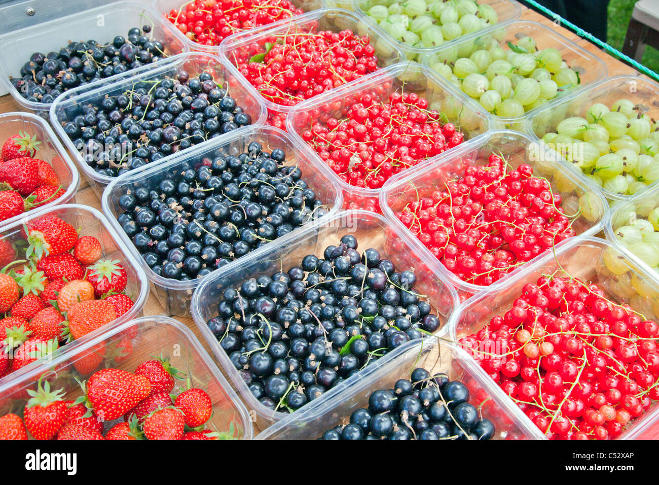 A selection of colourful fresh British soft fruit for sale on a greengrocer's barrow in Somerset England, UK Stock Photo